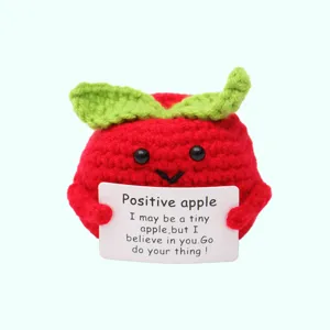 Primo piano dettagliato della bambola di peluche a forma di mela rossa uncinettata a mano.