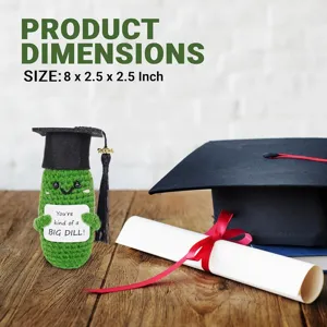 Detailed shot of crochet graduation pickle doll ornament with cap and diploma prop.