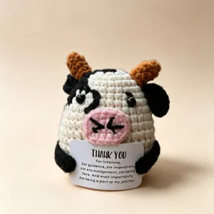 Handmade crochet cow plush toy holding thank you card, cute emotional support animal.