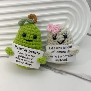Closeup of handmade crochet positive potato dolls with cute encouraging cards, soft yarn plush detail.