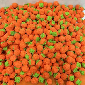 Nahaufnahme von handgemachten Häkel-Persimonen Anhängern, DIY Zubehör aus orangen Garnen.