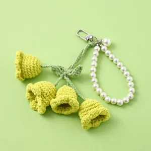 Handmade crochet lily of the valley keychain with pearl bead strap and metal clasp.
