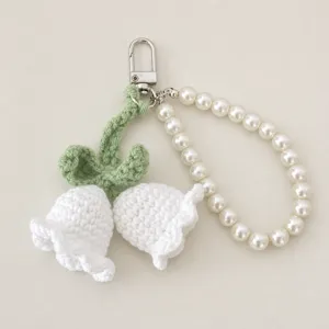 Handcrafted crochet lily of the valley keychain detail, pearl beaded bag charm accessory.