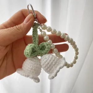 Handmade crochet lily of the valley keychain with pearl strap and metal clasp for cute bag charm.