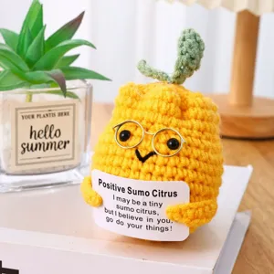 Close-up of cute handmade crochet citrus plush doll with glasses and card for lovely decor.