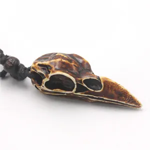 Close-up detail of the vintage distressed bird skull resin necklace pendant, punk gothic style.