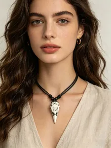 Close-up detail of retro punk crow skull pendant necklace with black cord for men women.