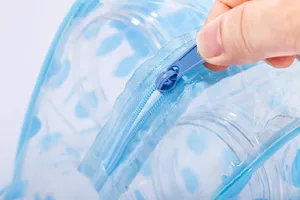 Borsa da toilette trasparente e blu in PVC impermeabile con dettaglio di chiusura zip.