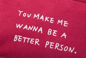 Detailed close-up of red canvas fabric featuring white English letter quote print design.
