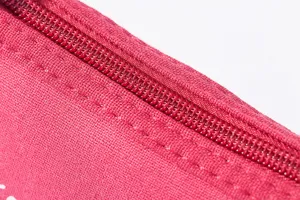 Red canvas zipper pouch detail closeup showing durable fabric texture and strong teeth zipper.