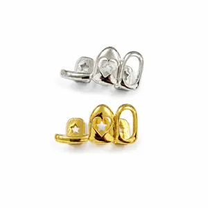 Close-up detail of silver and gold hip hop grillz with hollow star heart design teeth caps.
