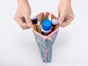 Close-up of portable cosmetic storage bag interior, showing open pouch with flamingo print.