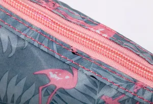 Close-up detail of the pink zipper and flamingo leaf patterned fabric of cosmetic storage bag.