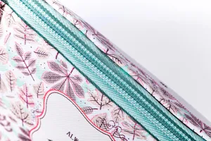 Detailed view of cosmetic bag zipper and leaf print pattern, compact and stylish design.