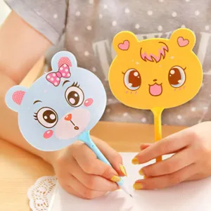 Close-up detail of cute cartoon bear shaped ballpoint pens in blue and yellow colors writing.