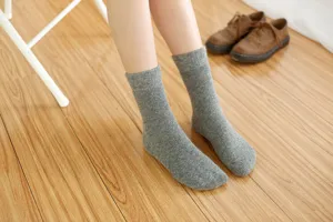 Nahaufnahme gemütlicher grauer Woll-Mittelsocken mit weicher Stricktextur und Rippbündchen-Details.