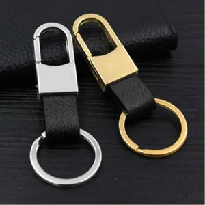 Detailed close-up of dual-tone metal and leather keychains in stylish silver and gold finishes.
