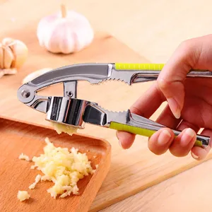 Close-up detail of manual zinc alloy garlic press crushing fresh garlic cloves easily.