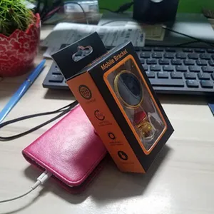 Closeup shot of a universal 360 degree rotatable metal mobile phone bracket in box on desk.