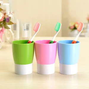 Detailed shot of colorful plastic toothbrush holders and matching brushes for home use.
