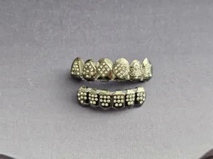 Close-up detail of hip hop grillz with sparkling rhinestones and poker suit symbols.
