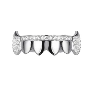 Close-up of iced out vampire fang grillz, silver plated hip hop teeth jewelry detail.