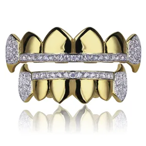 Detail view of gold plated hip hop grillz with clear zircon stones and vampire fangs design.