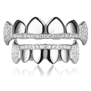 Close up detail of silver hip hop grillz teeth with sparkling zircon stones and vampire fangs design.
