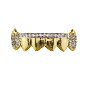 Gold hip hop grillz top teeth close up with sparkling zircon stones for party fashion.