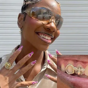 Close-up detail of luxury hip-hop bee zircon single tooth grillz dental accessory product.
