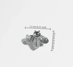 Close-up detail of silver bee grillz with sparkling micro-paved cubic zirconia stones.