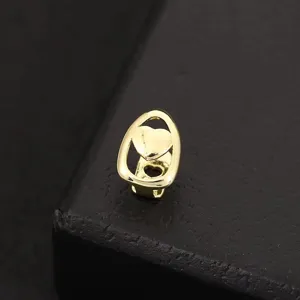 Close-up detail of a stylish gold hip hop grillz tooth cap featuring a cute heart design.