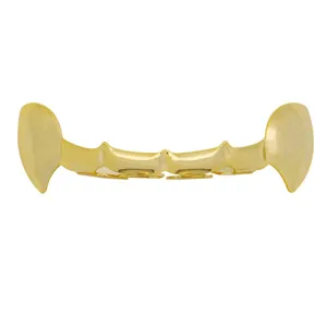 Close-up detail of glossy gold vampire fangs grillz, showcasing polished hollow hiphop style.