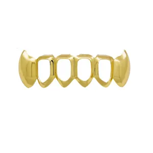 Closeup of gold hip hop grillz vampire fangs teeth cap, shiny cutout design for parties.