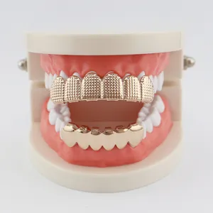 Hiphop gold grillz set for top and bottom teeth with textured grid and smooth design.
