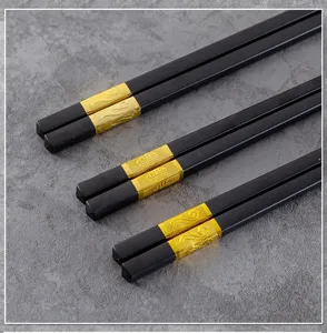 Detailansicht von Besteck-Stäbchen aus Legierung mit edlem schwarzem Körper und goldenen Enden.