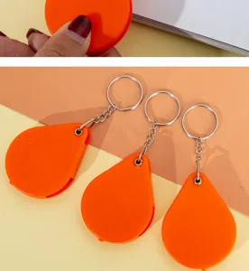 Detalle de llavero con lupa plegable portátil, brillante lupa de bolsillo naranja.