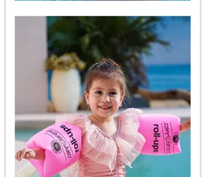 Primo piano di un bambino con braccioli gonfiabili rosa vicino alla bella piscina.