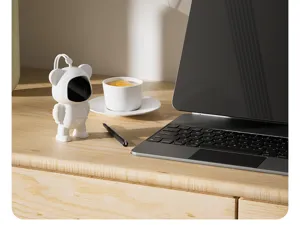 Close-up view of portable cartoon USB rechargeable hand warmer on wooden desktop scene setup.
