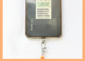 Phone tether patch detail showing metal clasp and secure hanging connector for straps.