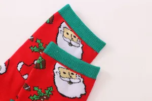 Cute Christmas socks for women, mid-calf length, red and green Santa Claus pattern detail.