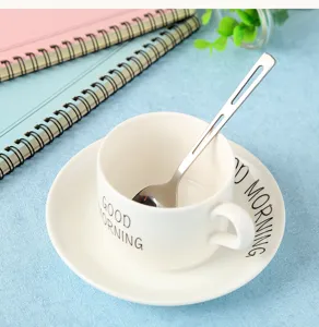 Detailed shot of a hollow handle stainless steel coffee spoon resting in a white ceramic cup.