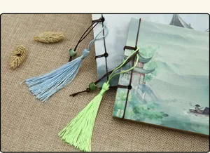 Traditional Chinese style notebook detail, vintage parchment paper with elegant tassel pendants.