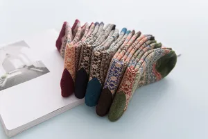 Nahaufnahme von vintage ethnischen Wollsocken ordentlich auf einem Buch gestapelt.