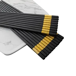 Hochwertiges schwarzes Legierungs-Staebchen-Set mit goldenen Enden, rutschfest und langlebig.
