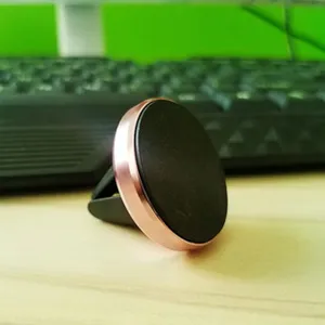 Magnetic car phone mount detail view, featuring a sleek rose gold metal rim and black pad.