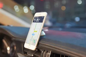 Detail view of the portable metal car phone mount installed securely on vehicle dash.