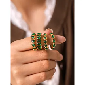 Detail view of stylish green zircon rings set in 18k gold plated titanium steel, stacking.