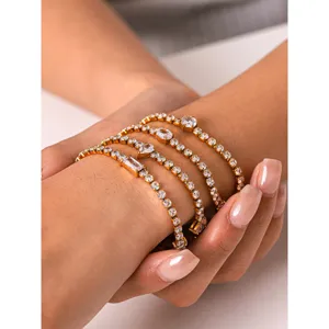 Gros plan détaillé de bracelets tennis dorés superposés scintillants avec des zircons.