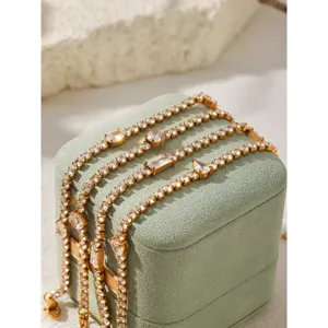 Gros plan de bracelets tennis en zircon en acier inoxydable plaqué or 18k sur boîte verte.